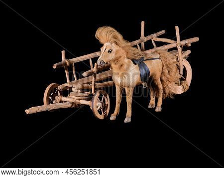 Model of vintage cart with brown horse isolated on black