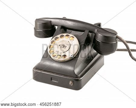 Vintage disk telephone with handset on wire isolated on white