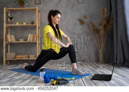 Fit Latin Woman In Fitness Clothes Using Online Personal Fitness Trainer Service In Laptop, Stratchi