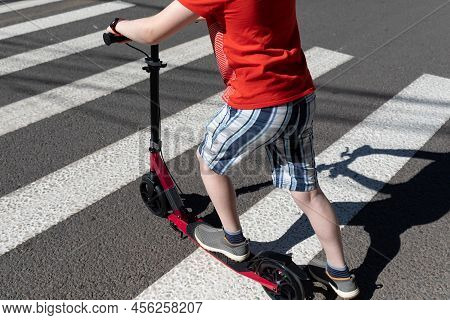 A Teenager With A Scooter Crosses The Road At A Pedestrian Crossing. Road Safety. Healthy Lifestyle.