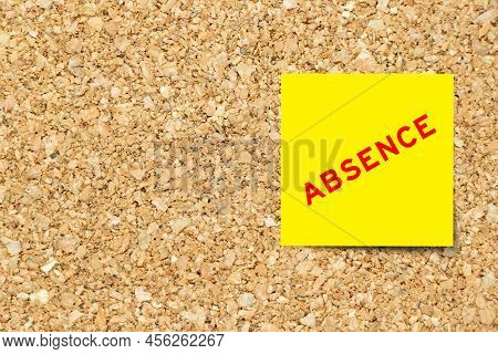 Yellow Note Paper With Word Absence On Cork Board Background With Copy Space
