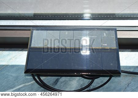 Solar Power Charger For Mobile Devices, Used At A Window