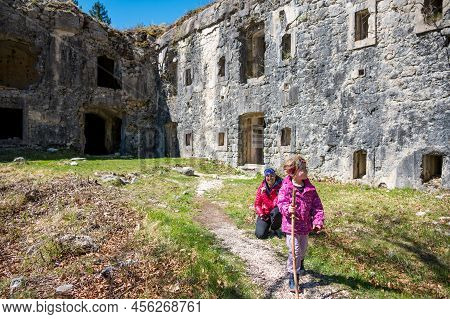 Mother And Daughter Posing In Front Of Ruins Of First World War Fortress.