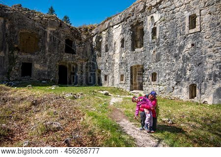 Mother And Daughter Posing In Front Of Ruins Of First World War Fortress.