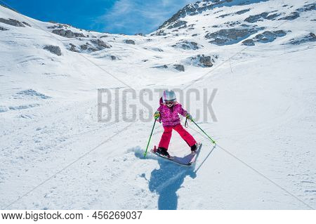 Cute Young Girl Learning To Skii At Winter Resort On A Sunny Day.