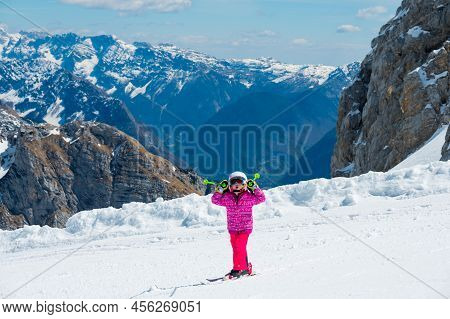 Cute Young Girl Learning To Skii At Winter Resort On A Sunny Day.