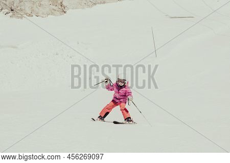 Cute Young Girl Learning To Skii At Winter Resort On A Sunny Day.