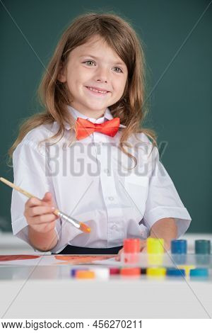Portrait Of Little Girl Smiling Happily While Enjoying Art And Craft Drawing Lesson. Child Girl Draw