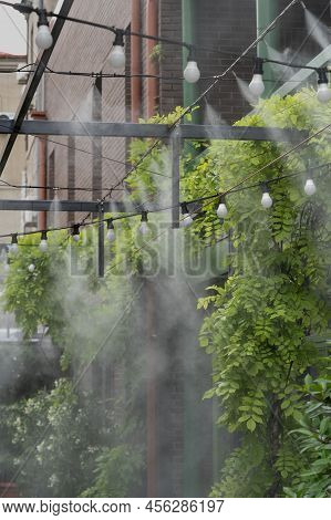 Fogging Outdoor Cool Misting System Working Hot Summer Day For Terrace In Cafe. Facility That Lowers