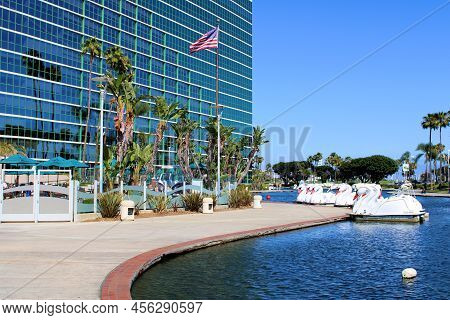 June 12, 2022 In Long Beach, Ca:  Swan Style Paddleboats Docked At The Lake Marina Besides The Resor