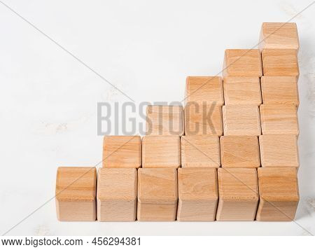 Stack of wood blocks in graph shape as metaphor to business rising