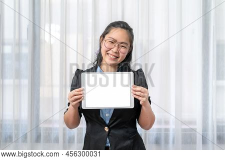 White Screen On Tablet Was Hold By The Asian Eyeglasses Woman, Is Smiling In Front Of Transparent Cu