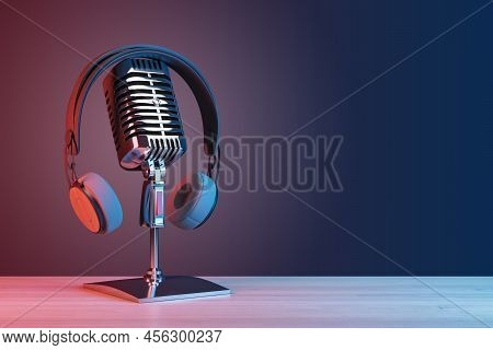 Podcasting And Radio Concept With Retro Microphone And Headphones On Empty Wooden Table And Dark Bla