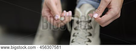 Close-up Of Woman Put Her White Boots On And Tie Laces Before Going Out. Fashion Beige Leather Winte