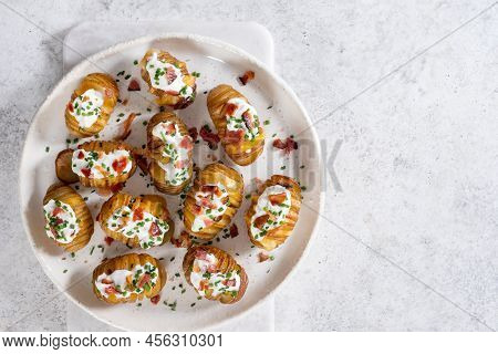 Baked Potato Stuffed With Cheese, Bacon And Sour Cream. Loaded Hasselback Potatoes