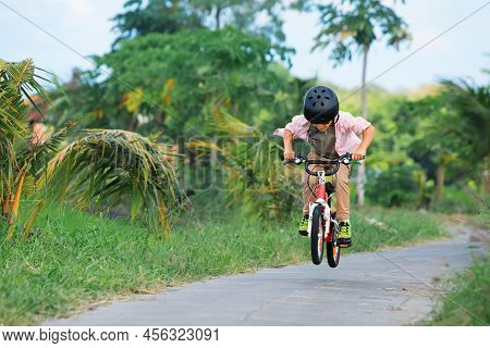 Country Cycling Walk. Young Rider Kid In Helmet And Sunglasses Riding Bicycle. Happy Child Have Fun 