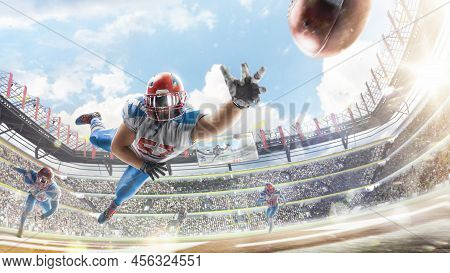 Sportsman In Action. American Football Player Catches The Ball And Flies In The Air. Touchdown. Amer