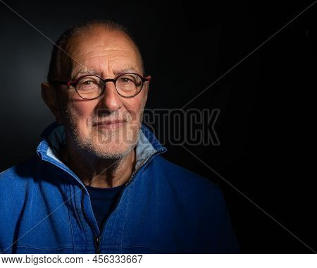 Older Man Wearing Glasses On Plain Background With Copy Space