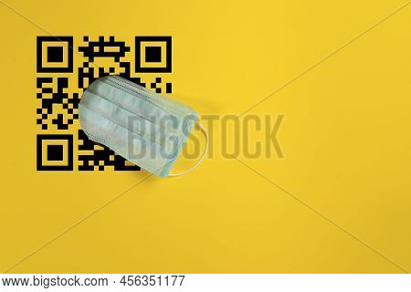 Protective Face Mask Through A Hole In A Yellow Background. Concept On The Topic Of Quarantine And T