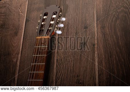 Classical Guitar Fretboard And Machine Head Up Close On A Dark Wood Background With Copy Space