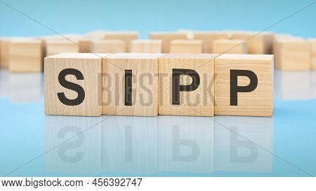 Word Sipp On Wooden Cubes On Blue Background. The Inscription On The Cubes Is Reflected From The Sur