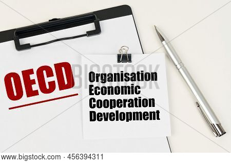 Business Concept. On The Tablet Is A Sheet Of Paper With The Inscription - Oecd And Stickers With Th