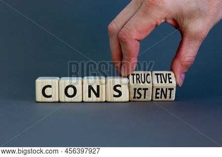 Constructive Or Consistent Symbol. Businessman Turns Cubes, Changes The Word Consistent To Construct