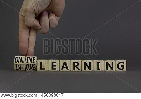 Online Or In-class Learning Symbol. Businessman Turns Cubes, Changes Words Online Learning To In-cla