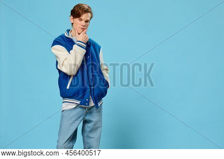A Handsome, Pensive, Stylish Young Man In A Fashionable Bomber Jacket And With Headphones Around His