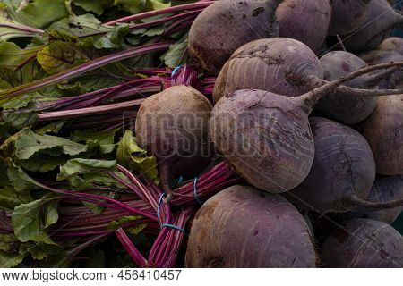 Closeup On Fresh Organic Purple Beets With Greens In The Pile On Farmers Market