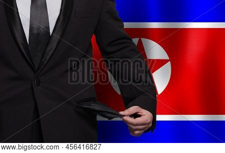 North Korea Flag Background With Man Showing Empty Pockets. Financial Difficulties, Bad Economy, No 