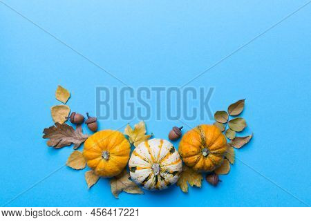 Autumn Composition Pumpkins With Fall Leaves Over Coloredbackground. Top View With Copy Space.