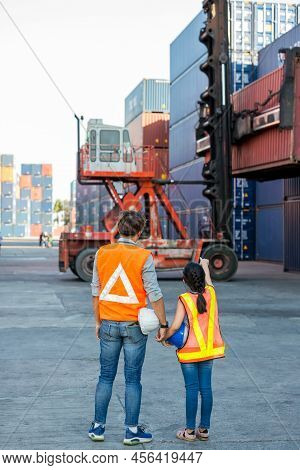 Father And Little Daughter Wearing A Safety Helmet At Container Cargo Site. Business Heir Concept. H