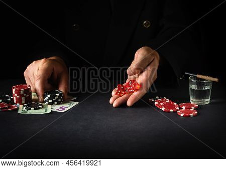 Dice Game In A Poker Club. Player Holding Two Dice Before Rolling On Dark Table In Casino.