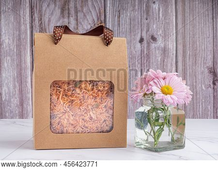 Package For Sale Of Sweet And Sour Crispy Noodles Or Mee Krob In The Thai Language Placed On A Gray 