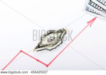 A Draw Of A Chart Of Rising Stock Prices On The Table Together With Three Dollar Banknotes Made By R