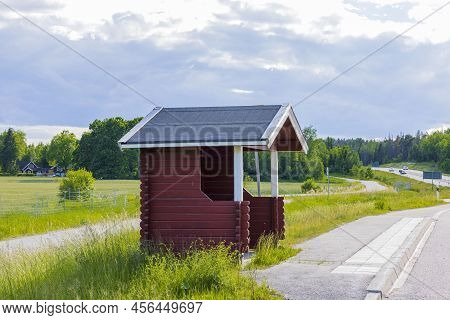 View Of Typical Red Old Standard Bus Stop On Beautiful Nature Landscape Background. Sweden.