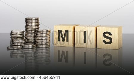 Mis. Wooden Cubes. Blocks Lie On A Black Background. Stacks With Coins. Inscription On The Cubes Is 