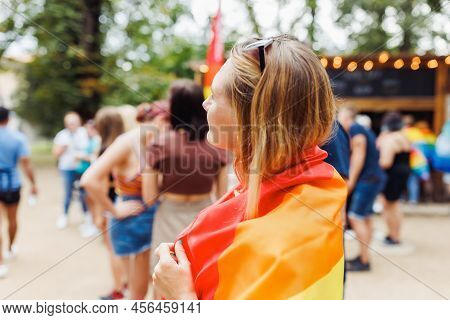 Happy Young Blonde Hair Woman Covering With Lgbtqi Pride Rainbow Flag On The Street In The Park. Lgb