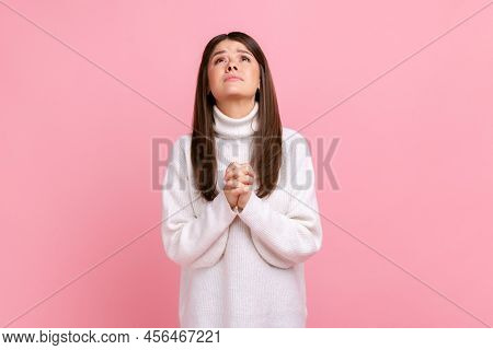 Young Adult Attractive Brunette Girl Looking Up With Hands In Prayer, Sincere Saying Please, Apology