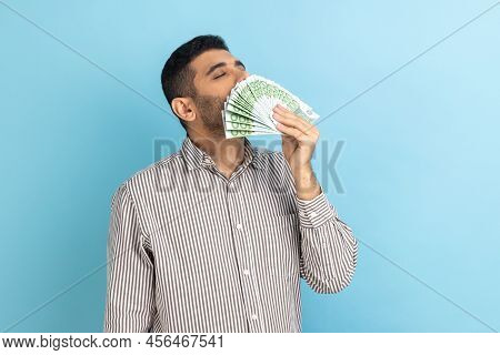 Portrait Of Avaricious Businessman Smelling Euro Banknotes, Enjoying Lottery Win, Big Profit And Wea