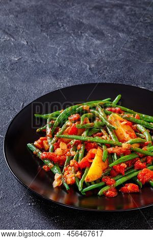 Fasolakia Lathera, Green Beans, Onion And Potatoes Stewed In Tomato, Herbs And Olive Oil On Black Pl