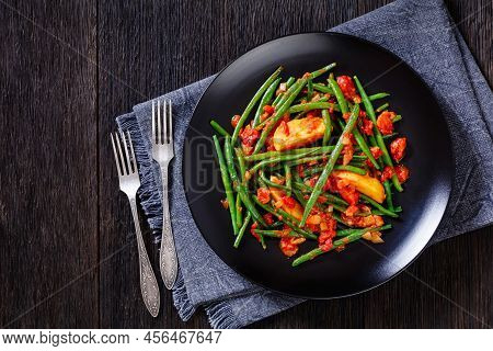 Fasolakia Lathera, Green Beans, Onion And Potatoes Stewed In Tomato, Herbs And Olive Oil On Black Pl