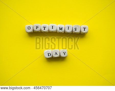 World Optimist Day. Yellow Background With Text Optimist Day On Wooden Cubes And With Place For Your