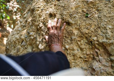 Elderly Asian Male Geologist Researcher Touches Rocks With His Hands To Analyze Surfaces In Mae Wang