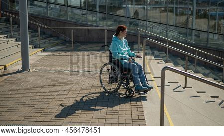 A Caucasian Woman In A Wheelchair Cannot Go Down Stairs Without A Ramp. Hard To Access Environment.