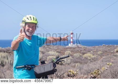 Happy White-haired Active Seniorman Cycling Off Road With Electric Bicycle At Sea, Elderly Caucasian