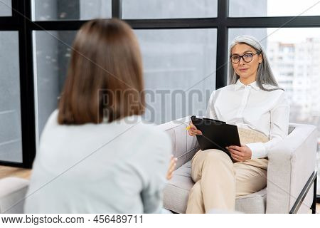 Senior Grey Haired Therapist Expresses Support And Empathy To A Upset Female Patient During Therapy 