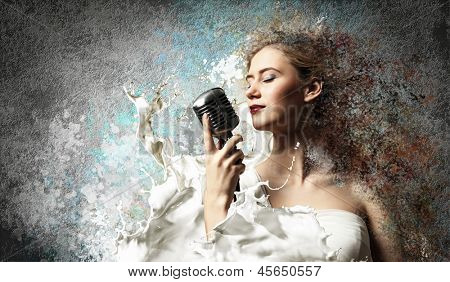닫힌 눈 색 배경에 대해 마이크를 들고 여자 금발가 수의 이미지