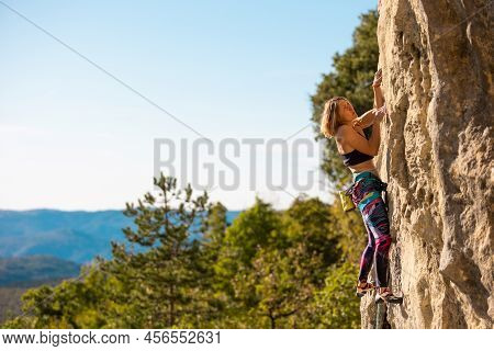 The Girl Climbs The Rock. The Climber Trains On Natural Terrain. Extreme Sport. Outdoor Activities. 